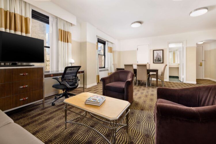 A wide view of a hotel suite with a living area and dining table