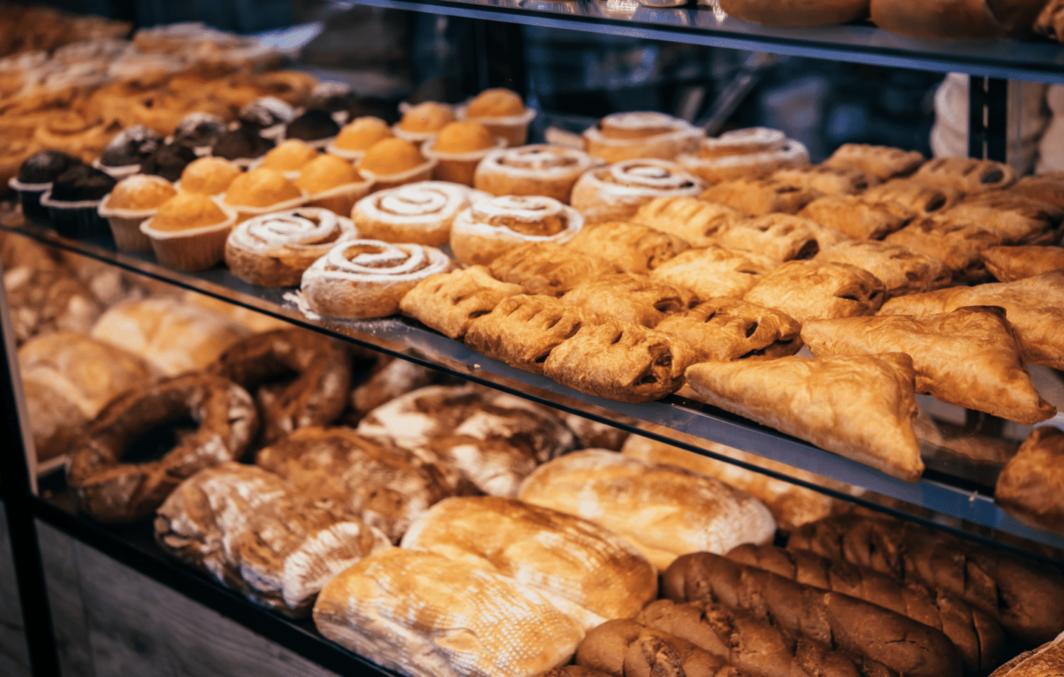 A display case filled with various types of pastries and baked goods.